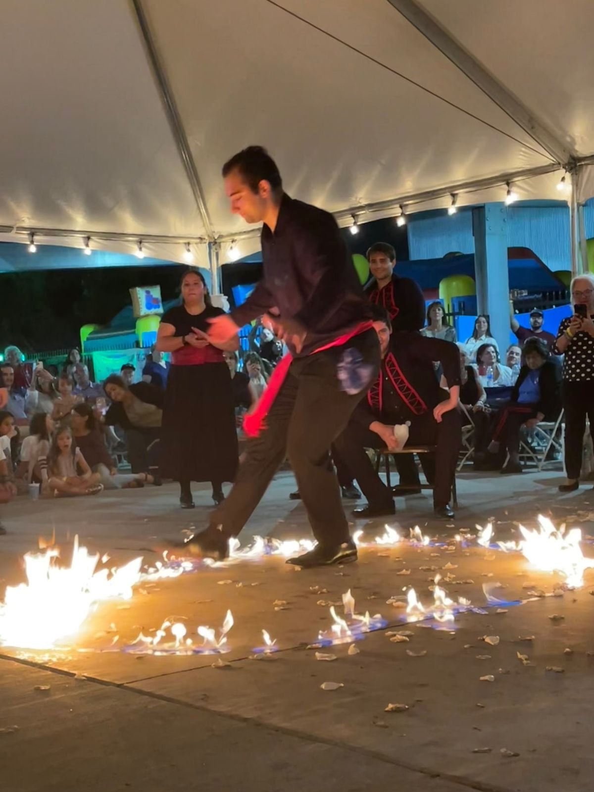 Dancer stepping through a ring of fire under the tent