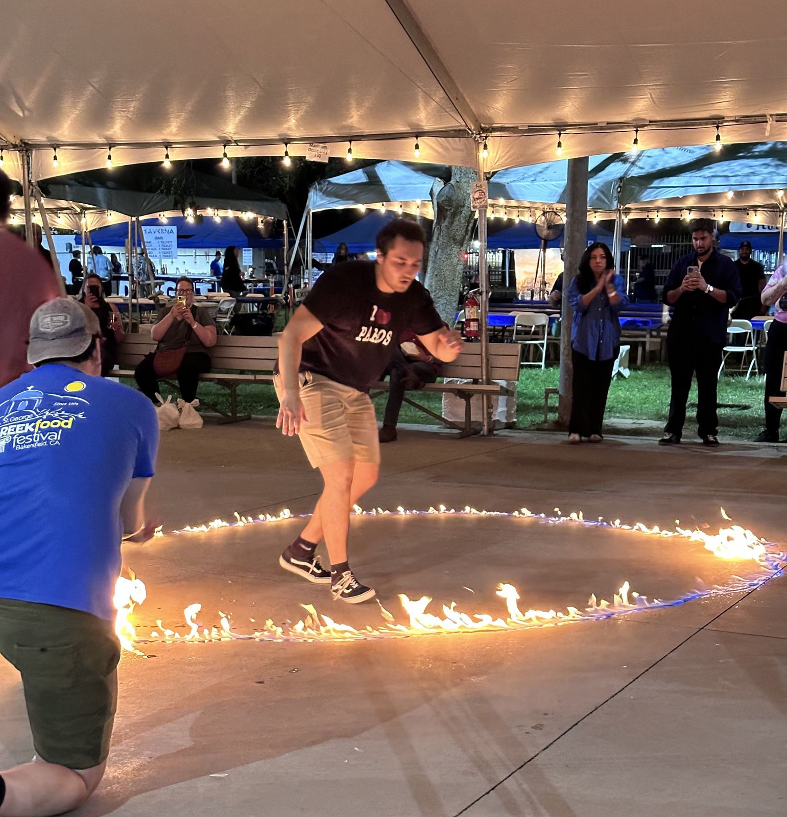 Guest jumping through a ring of fire under the tent